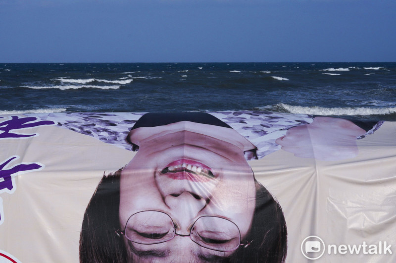 海灘上，競選帆布上的候選人肖像僅露出臉孔，非常詭異與超現實，成為冬季的蘭陽溪口海灘獨特的地景。   圖：張良一/攝
