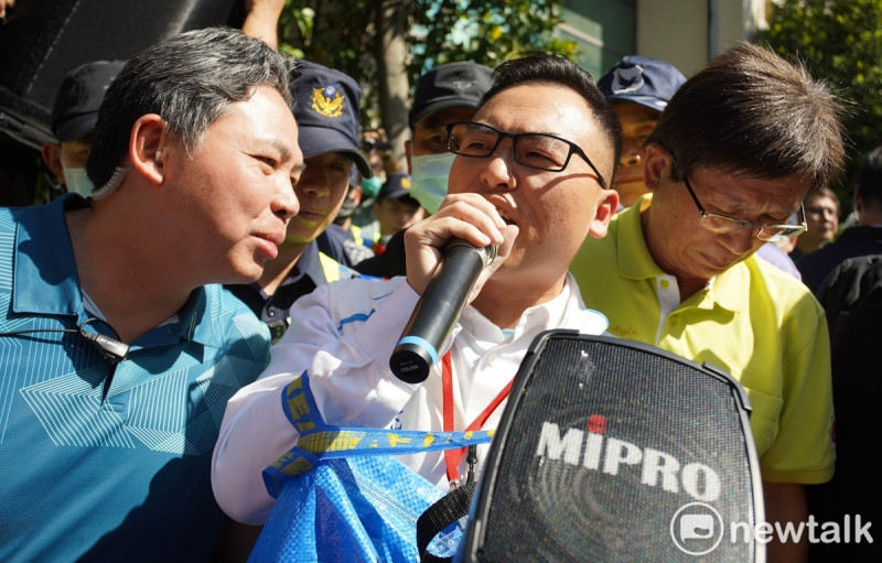 新黨立委候選人游智彬突現身桃市選委會場外，手持大聲公質問特地來為桃市黨籍立委參選人站台的民進黨總統參選人賴清德「違建拆不拆？」   圖：林昀真/攝