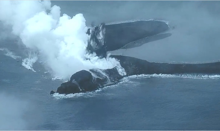 日本小笠原群島硫磺島南部海岸火山噴發冷凝岩石島，遭目擊還在持續噴發中。畫面中白色氣體為「潛水蒸氣噴發」，中間黑色部份則為新的火山灰、岩石碎屑噴發。   圖：翻攝「X」@JCG_koho