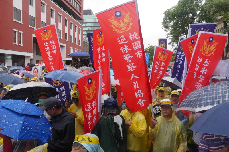 儘管下著滂沱大雨，不少軍公教警退休人員仍穿著雨衣到場抗議。   圖：趙婉淳/攝