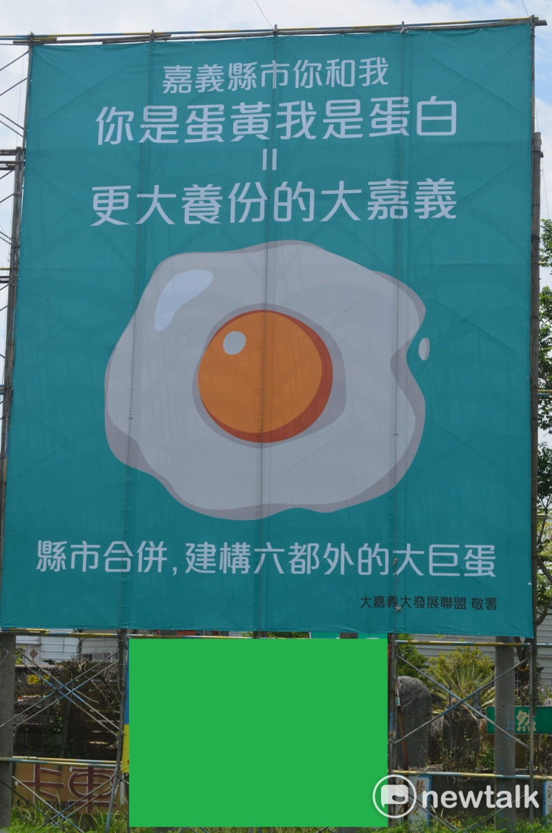一面「蛋黃蛋白」的戶外看板，引發嘉義縣市政府互別苗頭。   圖：蔡坤龍/攝