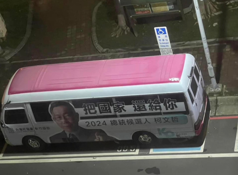有網友拍攝到一輛粉紅色車頂，車側印有柯文哲照片及招牌「把國家還給你」標語的中型巴士，臨停在路邊車格，然而因其車身較長，竟橫跨至一旁身障專屬車位。   圖：擷自臉書「朗員大」
