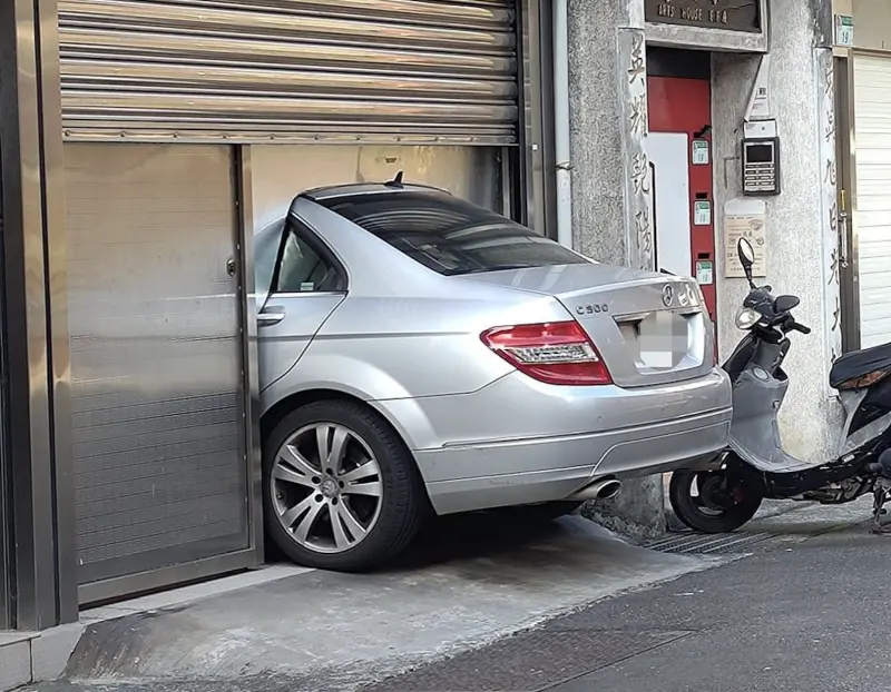 ▲一名汽車車主將自家透天1樓打造成車庫，卻因空間太小，而讓半個車屁股都露在屋外，他也找人特別訂製專屬鐵板來「關門」。（圖／翻攝自臉書社團「路上觀察學院」）   