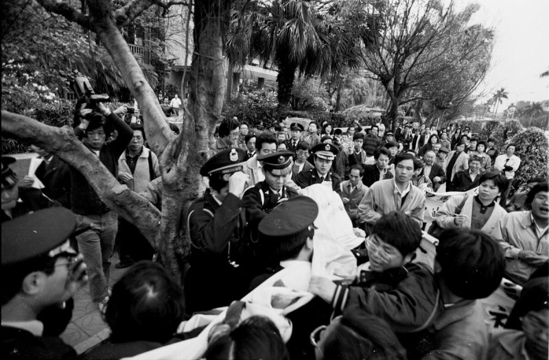  1989年3月蔡文旭在立法院聲援馬赫俊神父，警方搶奪聲援布條，蔡文旭與警方拉扯，要回布條。 圖：邱萬興攝影。 