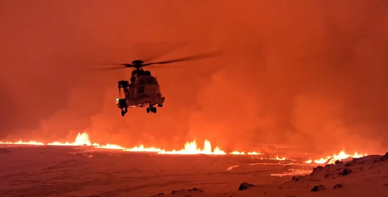 冰島海岸警衛隊派出直升機觀察現場，直升機盤旋在從地面裂縫中噴出的發光熔岩上空。   圖：翻攝自 BlackSite X（前推特）帳號
