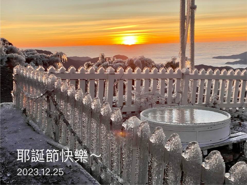 玉山一片雪白，氣象站更出現「冰晶圍籬」，搭配橘紅色的日出，相當有耶誕氣氛。   圖：取自鄭明典