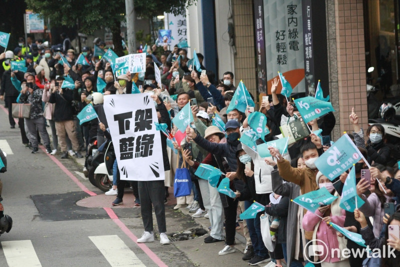 民眾黨總統候選人柯文哲支持者在路邊揮手，還有民眾高舉「下架藍綠」標語。   圖：周煊惠 / 攝