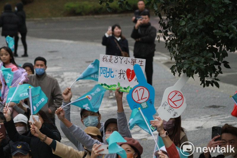 民眾黨總統候選人柯文哲車掃,路邊支持者高舉自製標語。 圖:周煊惠 / 攝