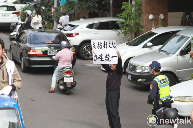 民眾黨總統候選人柯文哲今(7)早在高雄市區掃街拜票，有民眾高舉「支持柯文哲加速統一」。   圖：周煊惠 / 攝