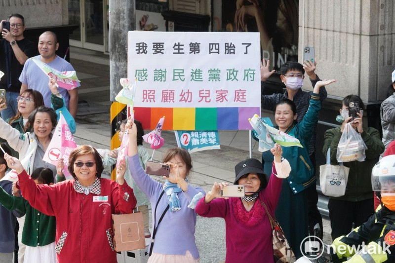 一位即將生第四胎的媽媽舉牌感謝民進黨政府。   圖：張良一/攝