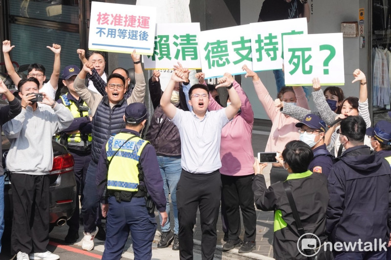 一些民眾舉著「賴清德支持廢死？」手舉牌，在車隊經過時對著賴喊口號比倒讚。   圖：張良一/攝