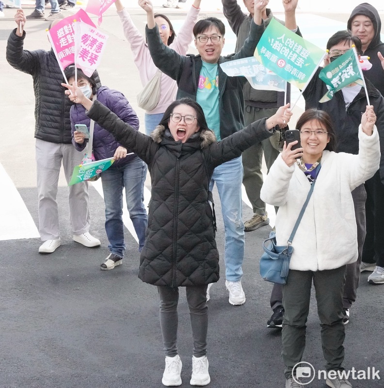 台中市區一位女性選民在賴清德掃街車隊經過時，雙手高舉賴清德蕭美琴的競選旗幟，表達支持之意。   圖：張良一/攝