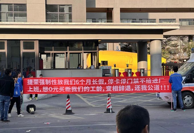 廣東捷榮工廠員工因不滿新政策強制放假 6 個月,到工廠門口舉紅布條抗議維權。