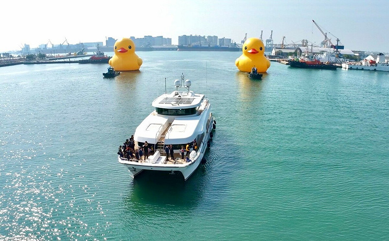 遊艇迎接兩隻黃色小鴨入港。   圖：高雄市觀光局/提供