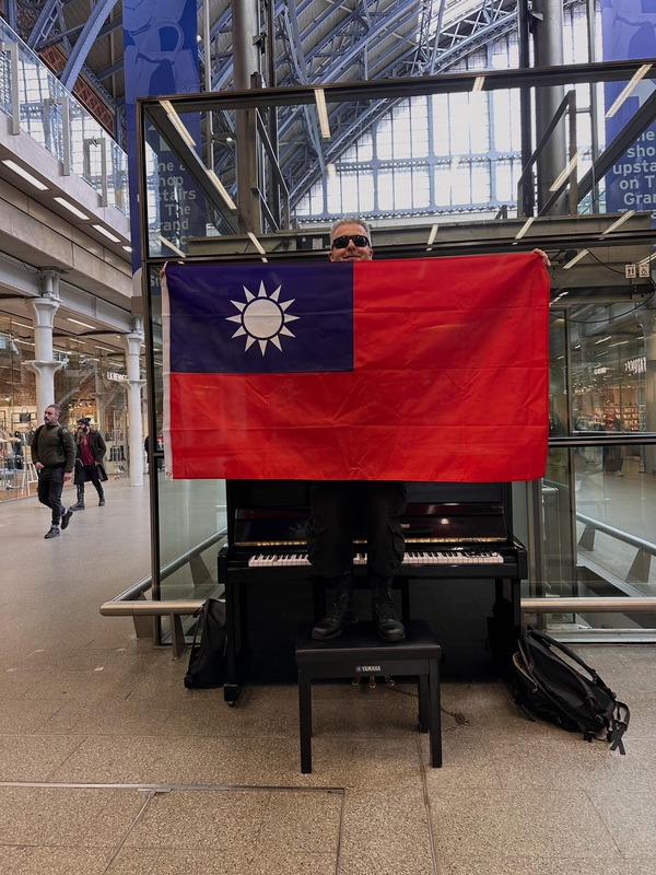 上個月遭小粉紅鬧場而聲名大噪的英國鋼琴家卡瓦納，近期屢在事發地點以「維尼」相關產品諷刺中共，更曾手持中華民國國旗聲援台灣。   圖：取自臉書「Dr K Boogie Woogie」