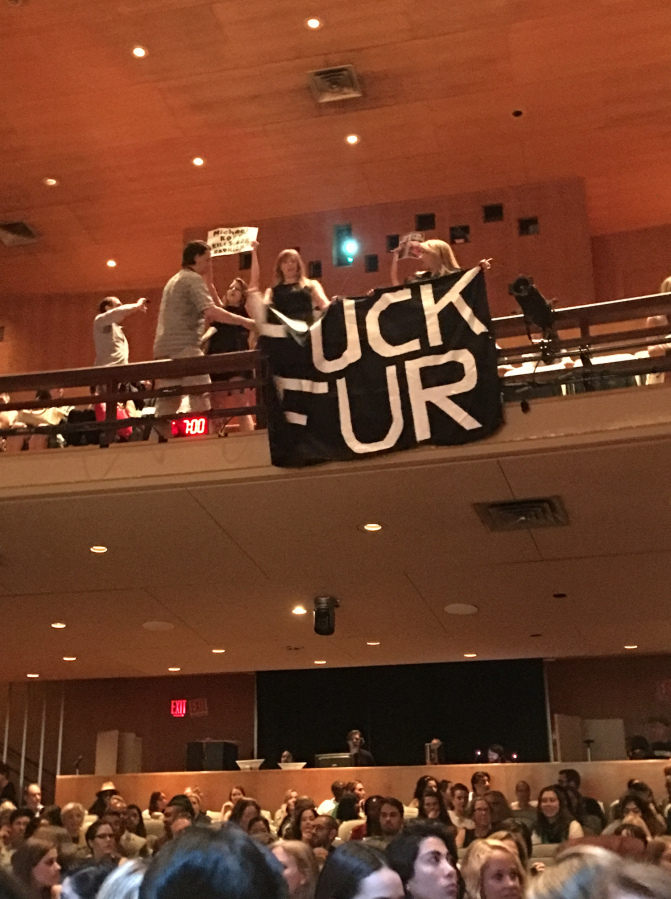 麥可寇爾斯在紐約開講，中途遭反皮草人士短暫鬧場抗議。   圖：取自WWD網站