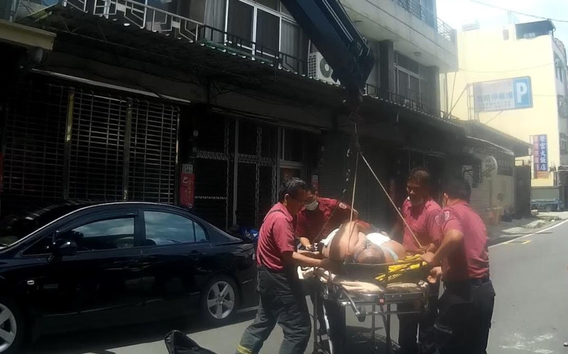 嘉義市一名體重150公斤的男子昏迷，生命垂危，消防隊員利用機器吊必將他從二樓陽台吊下，救回一命。   圖：嘉義市政府/提供