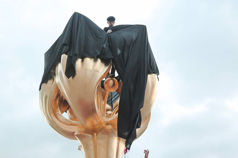 中國國家主席習近平將訪問香港前，「香港眾志」秘書長黃之鋒等人26日前往金紫荊廣場，以大型黑布遮蓋金紫荊雕塑抗議。   圖：翻攝香港眾志臉書