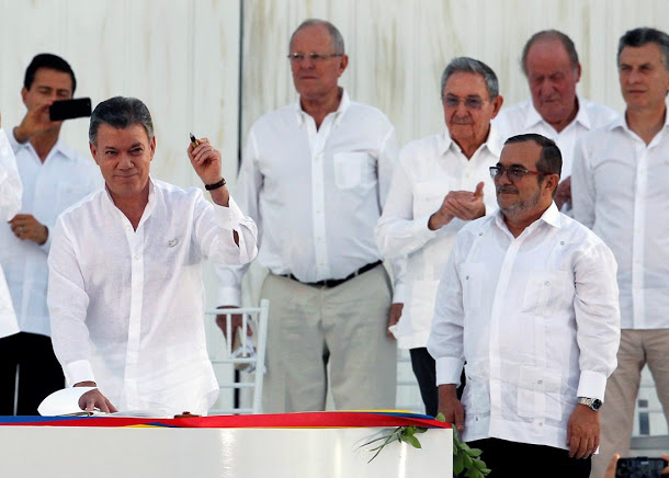 2016年9月，哥倫比亞總統桑托斯（左）高舉彈殼做成的鋼筆，與Farc領袖提莫千科（右），先後簽下和平協議。      圖：達志影像/路透社資料照片