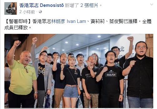 參與黑紫荊行動被捕的黃之鋒（中）等人，30日清晨全數獲得釋放，在北角警署外高喊口號。   圖：翻攝香港眾志臉書