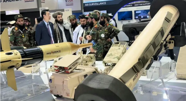 塔利班代表團手指武器模型，向中國人員詢問詳細訊息。