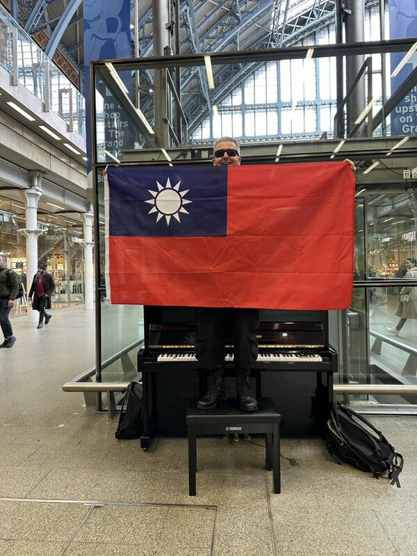 英國鋼琴家卡瓦納在鋼琴前手舉中華民國國旗，寫「Would love to visit Taiwan sometime…(很想去台灣看看…)」。   圖：翻攝「X」@brenkav