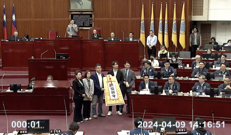 民眾黨團贈送「平安符」給台北市長蔣萬安。   圖：翻攝議會直播畫面