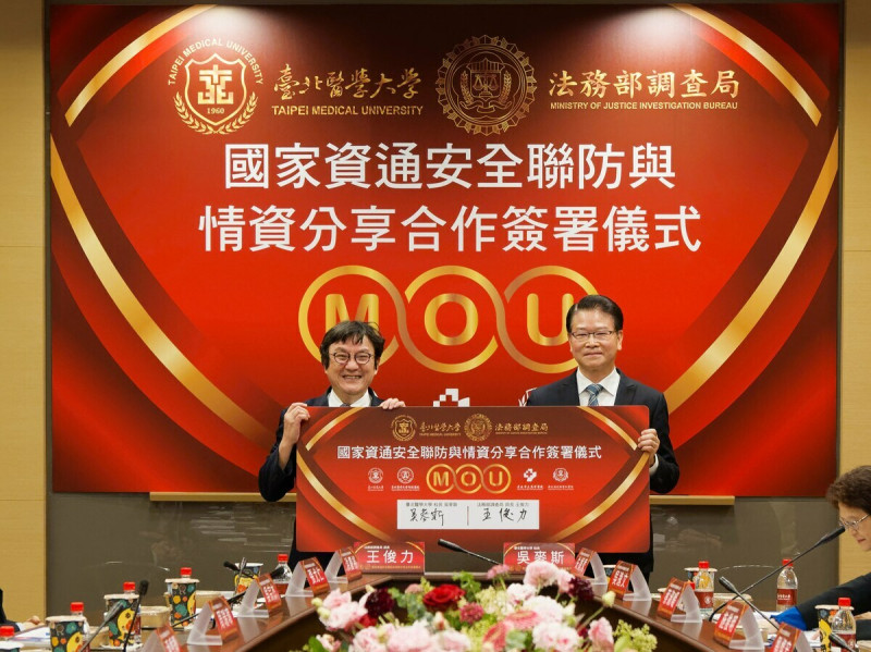 台北醫學大學與法務部調查局23日簽署國家資通安全聯防與情資分享合作備忘錄，由吳麥斯校長(左)與王俊力局長(右)代表簽署。   圖：台北醫學大學／提供