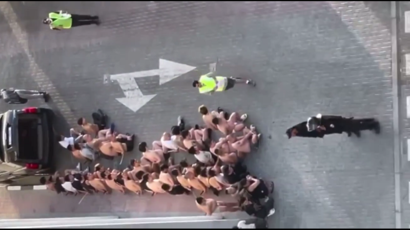 影片中顯示杜拜的某一詐騙園區受到警方打擊，可以看到一大群人坐在地上接受警方調查，在另一端的一群人甚至有的只穿著一條內褲。   圖 : 翻攝自影片