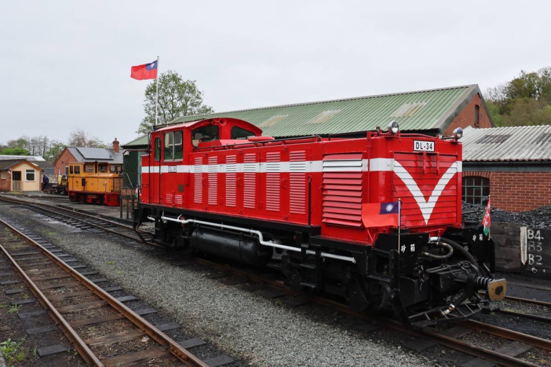 DL-34柴油機關車經典紅色火車頭搭載著國旗，迎風在當地無垠的秀麗綠野飄揚。   圖：林業及自然保育署／提供