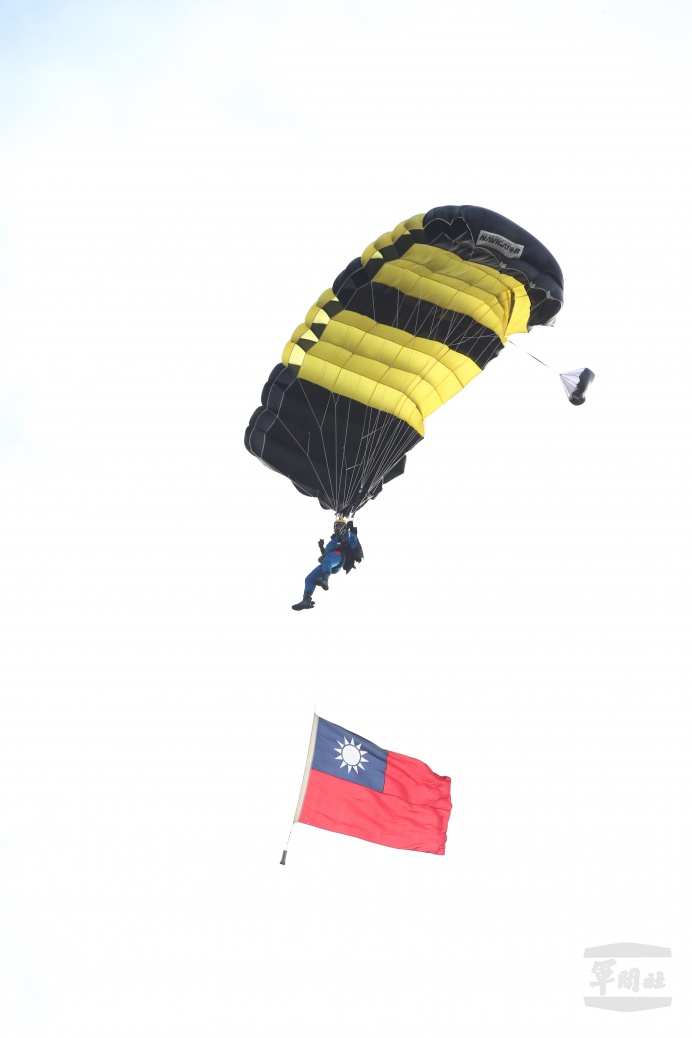 神龍小組組員攜帶國旗等道具，自4500英呎高空降落地面．   圖：翻攝自軍聞社網站