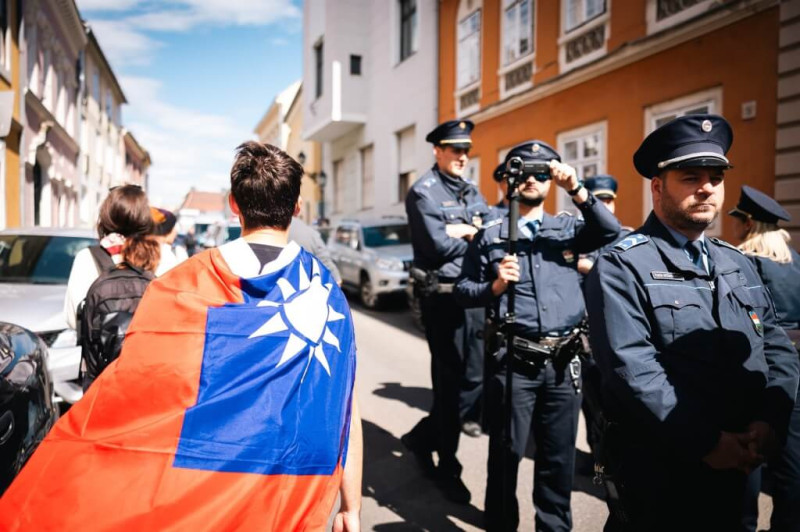 習近平出訪匈牙利，身披台灣國旗的當地民眾在布達城堡抗議，大批警力駐守在旁。   圖：翻攝TomposM臉書