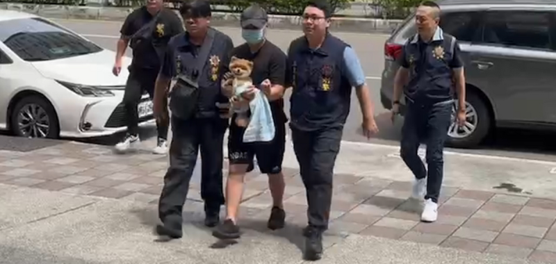 陳女丈夫被警方視為頭號嫌疑人，並於今(12) 日被押進三重分局，而過程中仍不忘緊抱愛犬。   圖: 翻攝自記者爆料網 臉書