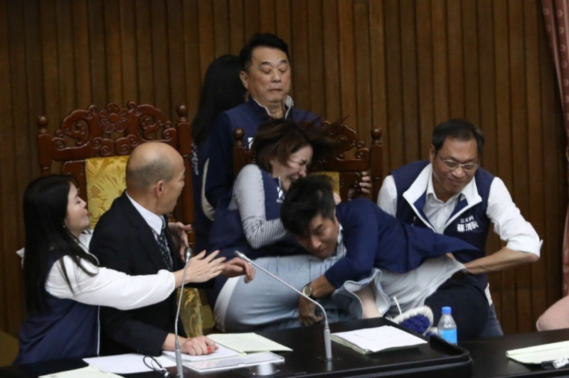 民進黨立委鍾佳濱縱身一跳上主席台，不慎將藍委陳菁徽環抱跌至地板。   圖：立法委員陳菁徽辦公室提供