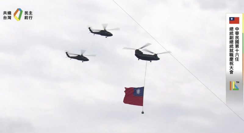 國防部表示，今（20）日領唱國歌時，由陸軍CH-47SD契努克中型運輸直升機，吊掛巨幅國旗1面，在2架UH-60M黑鷹直升機護衛下，搭配AH-64E、AH-1W攻擊直升機及海軍S-70C反潛直升機各3架，由北向南編隊飛行通過會場上空。   圖：翻攝自賴清德臉書直播