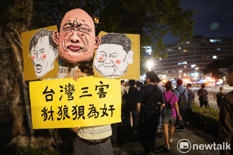 一位民眾高舉嘲諷韓國瑜、傅崐萁和黃國昌的圖像，表達對三人的不滿。   圖：張良一/攝