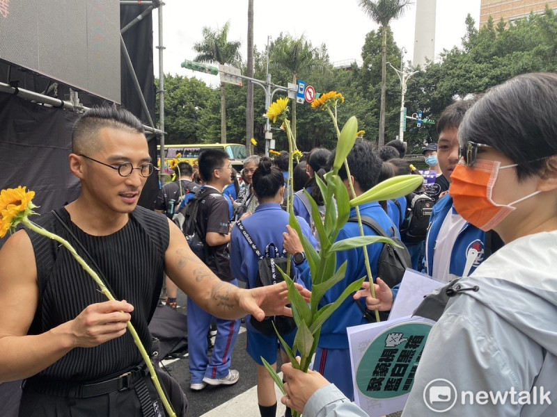林先生和同事自掏腰包買了千朵太陽花和百合花免費發送給來參加集會的民眾。   圖：林昀真/攝