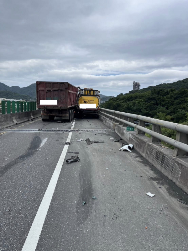 現場一輛大貨車不明原因衝撞，將緩撞車擠壓在外側護欄，造成雙向道路無法通行。   圖：翻攝自記者爆料網