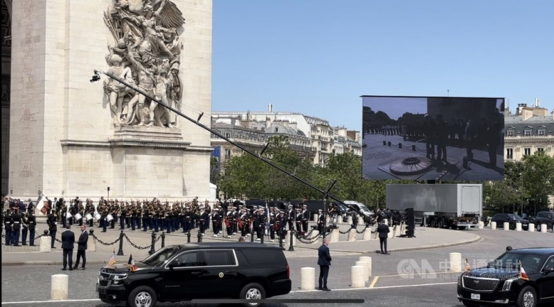 法國總統馬克宏和美國總統拜登在儀式中為凱旋門下的無名戰士墓獻上鮮花，並添加地上的永恆火焰。   圖：中央社