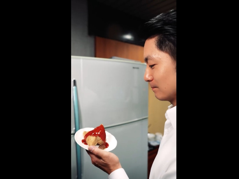 台北市長蔣萬安拍攝影片分享端午節當日的午餐，是淋滿甜辣醬的粽子。   圖：截取自 蔣萬安 Facebook 分享影片