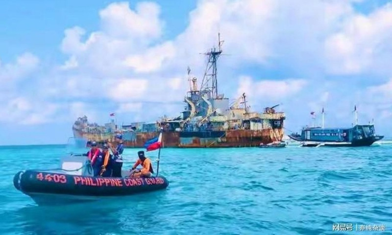 在菲律賓「坐灘」的馬德雷山艦旁，菲方人員派出小艇，搶撈菲國軍方空投的補給物資。   圖 : 翻攝自網易