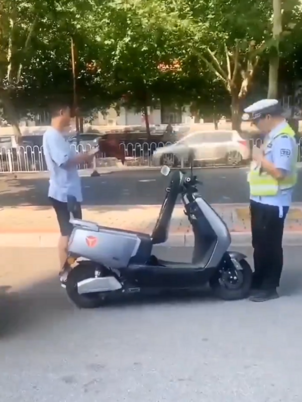 警察企圖沒收男子電動車時，男子直接從電動車後座拿出摺疊傘並攻擊警察。   圖：翻攝自 Daniel Fang X（前推特）帳號