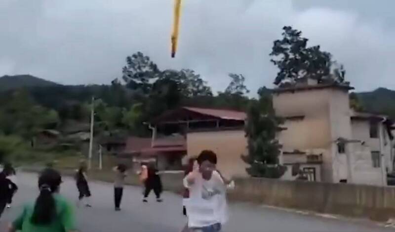 疑似長征2號丙運載火箭助推器墜落於貴州某村落，居民倉皇摀耳逃跑。   圖：翻攝X（前推特）