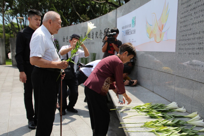 文化部長鄭麗君15日出席「解嚴30週年紀念會」時，與會者手持台灣原生百合，在白色恐怖紀念碑前獻花。   圖：文化部提供