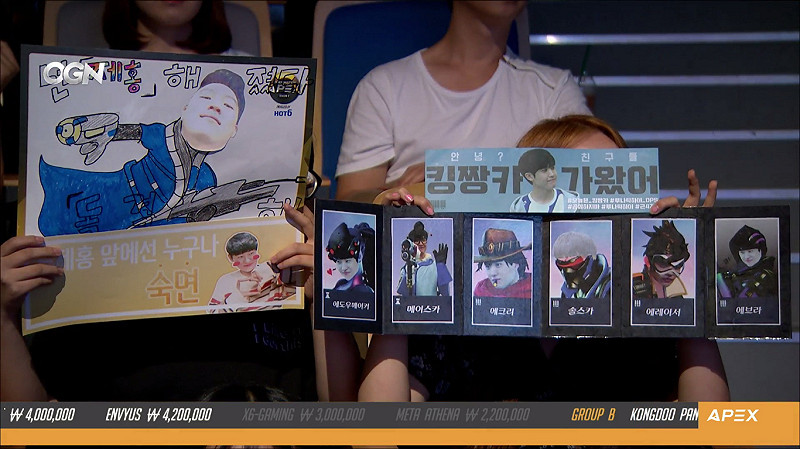 每當攝影機照到觀眾時，女粉絲往往會用加油板將臉部遮住。   圖翻攝自OGN的twitch