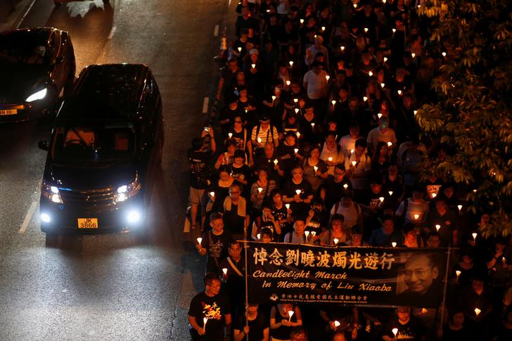 香港民眾冒著雨，以燭光遊行的方式，悼念諾貝爾和平獎得主劉曉波。   圖：達志影像／路透社