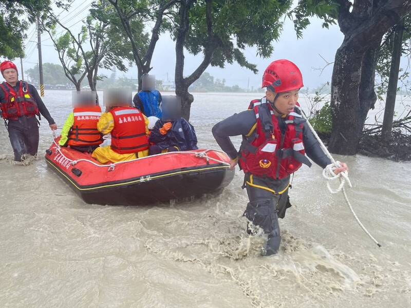 受颱風凱米影響，嘉義縣豪雨強風不減，25日雨勢持續且逢大潮，八掌溪水暴漲溢堤，消防人員協助民眾脫困。   圖：嘉義縣消防局提供