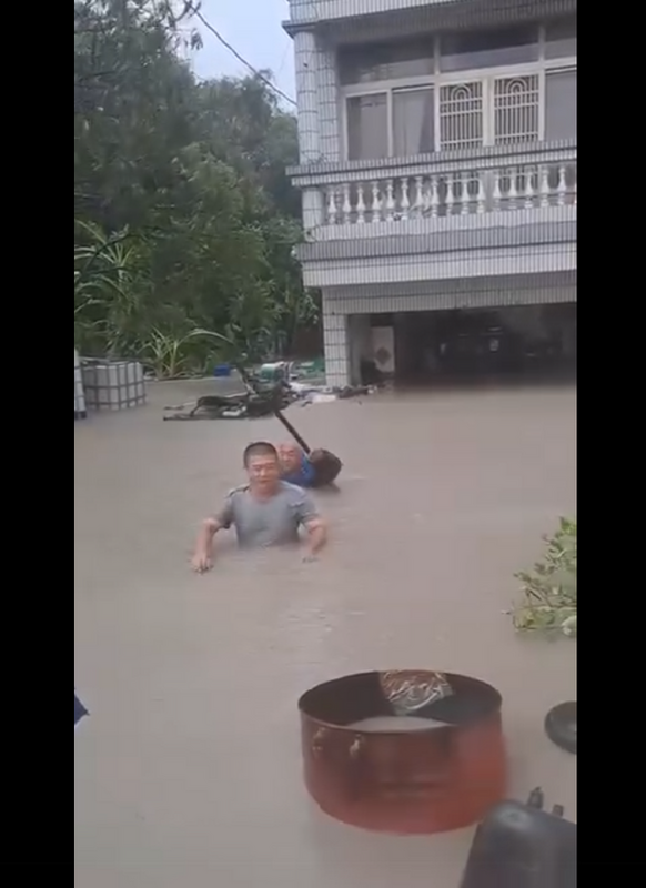 台南關廟嚴重淹水災情，水深竟已到民眾脅下逼近下巴，後方的房子更是接近一個樓層全都泡水。   圖：截取「臉書」王定宇粉絲專頁