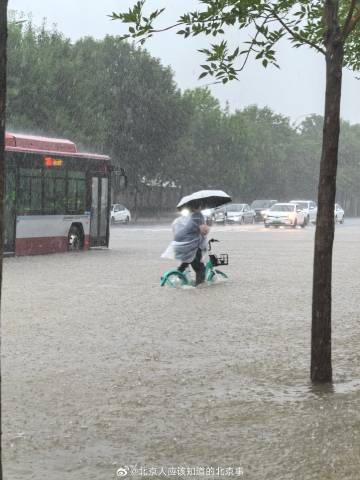 一位北京居民在豪雨與積水中騎著腳踏車。   圖：翻攝自 北京人應該知道的北京事 微博帳號