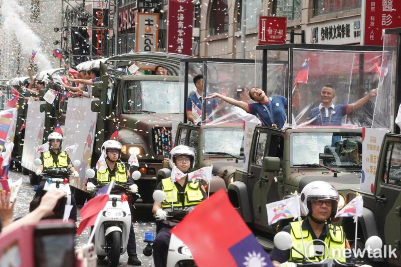 巴黎奧運拳擊銅牌選手陳念琴站在吉普車上向大樓上的民眾揮手致意。   圖：張良一/攝